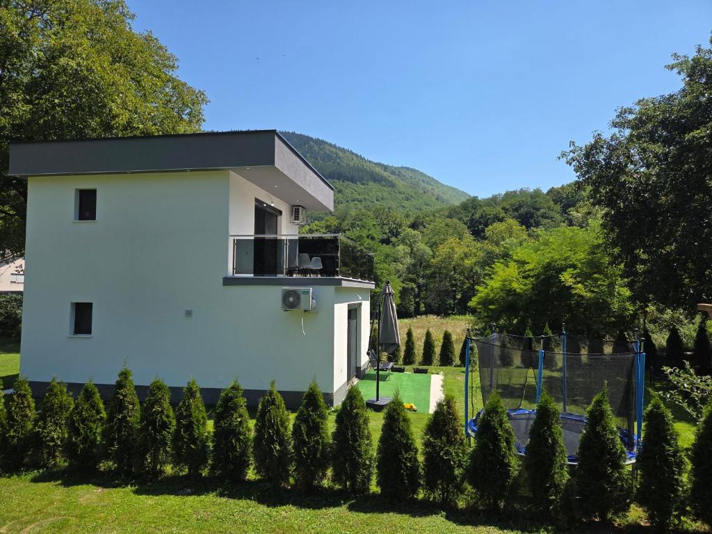 a white house in a yard with trees at Oaza mira 2 in Jajce