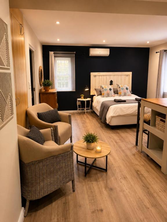 a bedroom with a bed and a couch and a table at Stay on Main - Studio Blue in Paarl