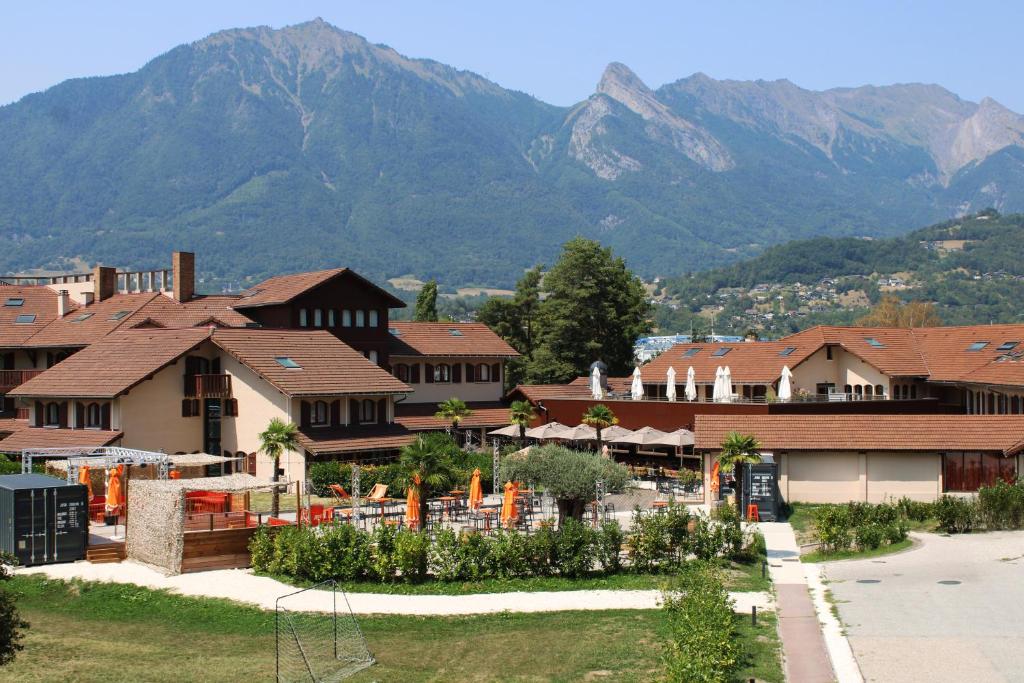 a view of a town with mountains in the background at Hotel Base Camp Lodge - Albertville in Albertville