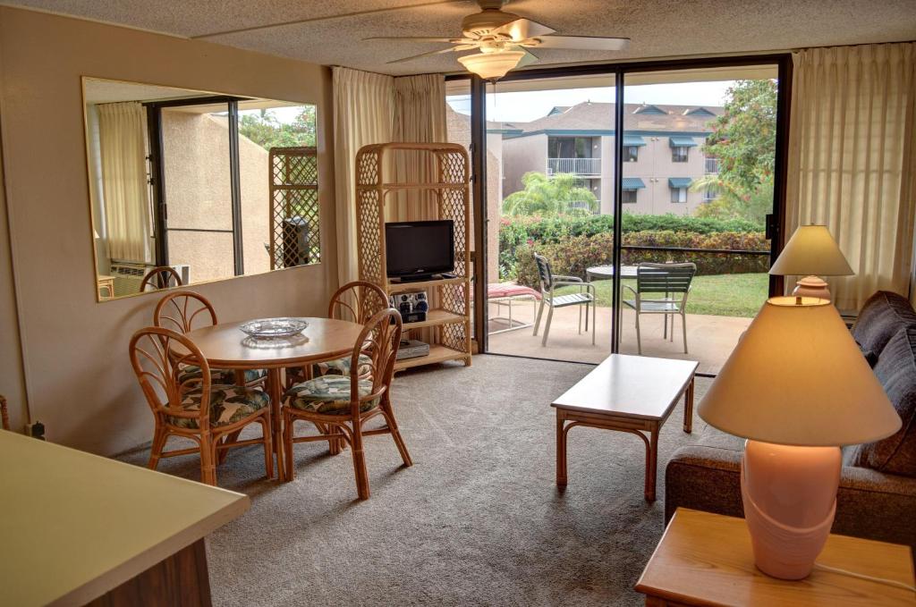 sala de estar con mesa, sillas y TV en Maui Vista 3101 en Kihei