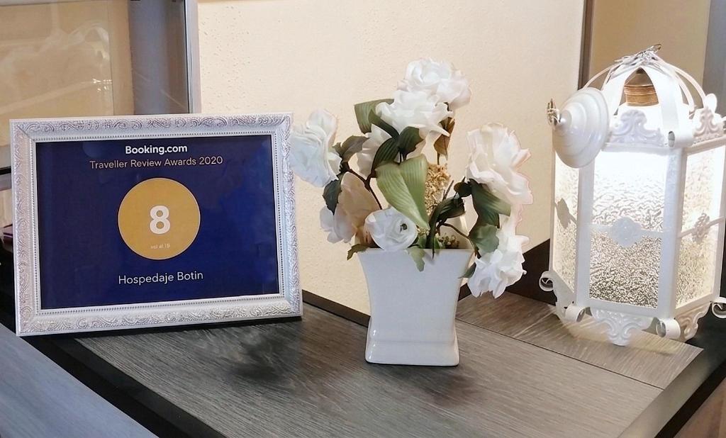 a table with a vase with flowers and a picture at Hospedaje Botin in Santander
