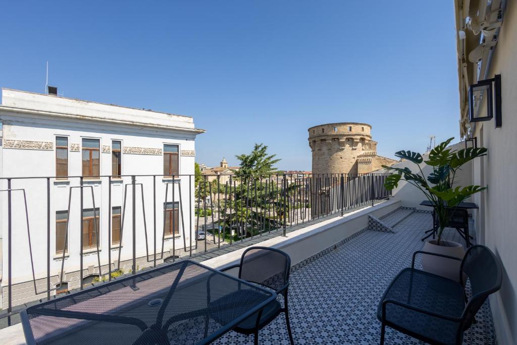 a balcony with two chairs and a lighthouse in the background at Palazzo Partenope in Vasto