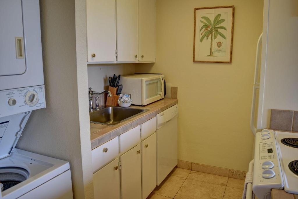 uma pequena cozinha com um lavatório e um micro-ondas em Maui Vista 3205 em Kihei