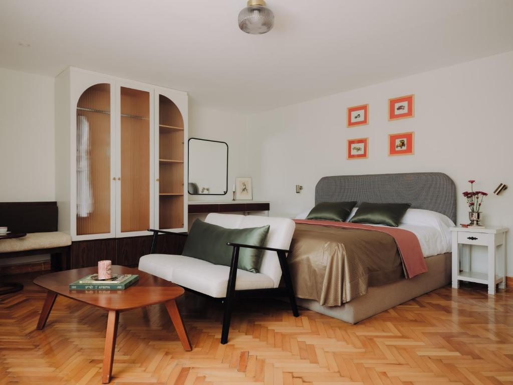 a bedroom with a bed and a chair and a table at Longchamps l Zamalek l Boutique Hotel with Breakfast in Cairo