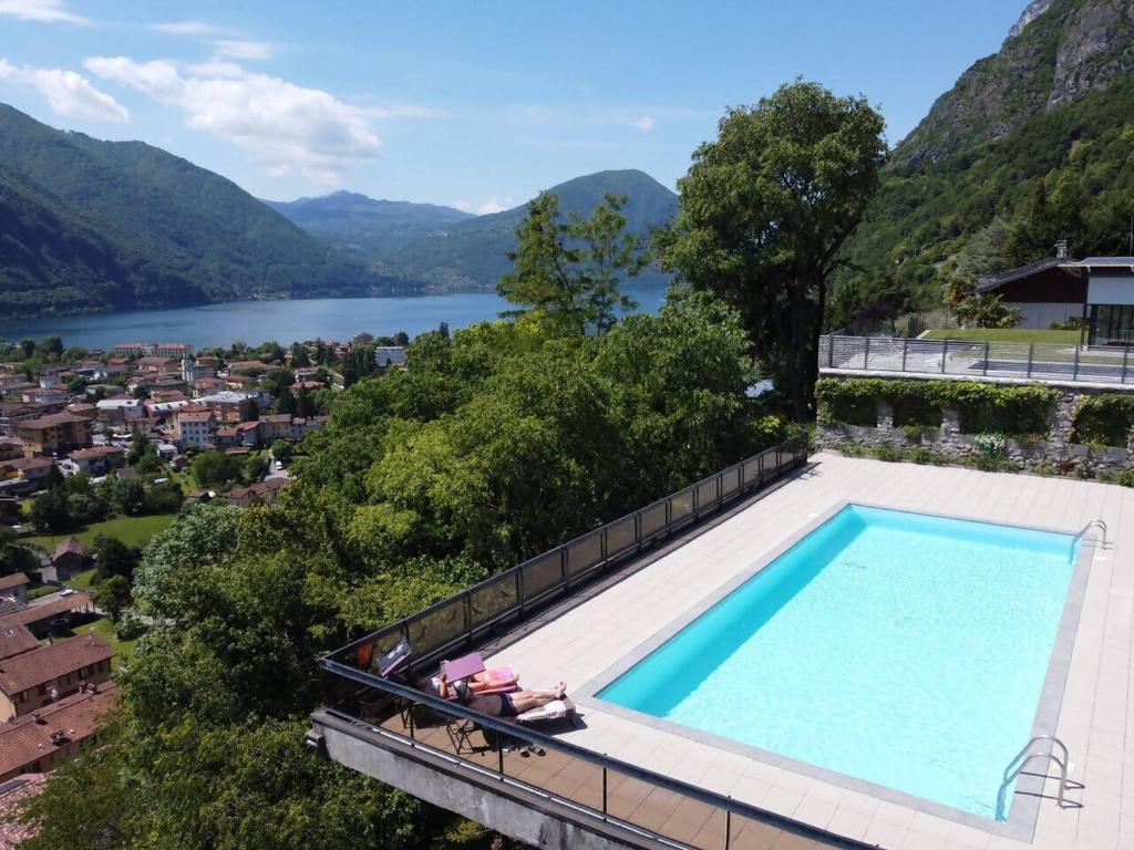 a swimming pool on top of a house with a view of a lake at Due laghi – Studio Apartment with Pool in Porlezza