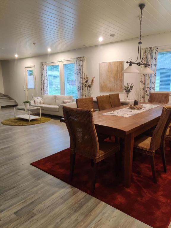 a living room with a wooden table and chairs at Omenapolun Onni in Taipalsaari