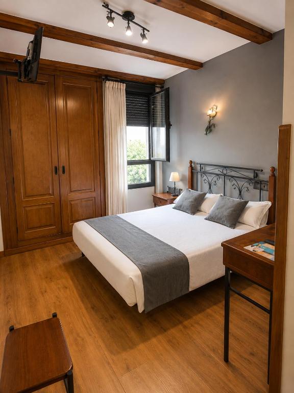 a bedroom with a large bed and a window at Alda Casco Antiguo in León