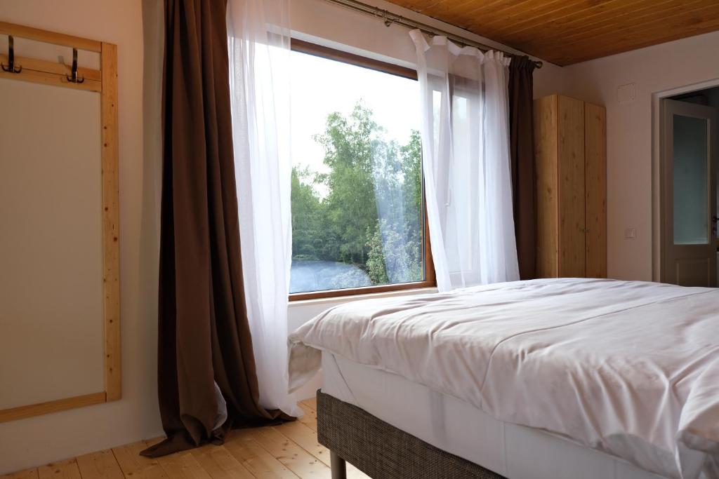 a bedroom with a bed and a large window at Cabana din vale in Cioclovina