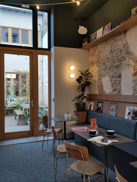 a restaurant with tables and chairs and a window at SLO Hostel Lyon Saxe in Lyon