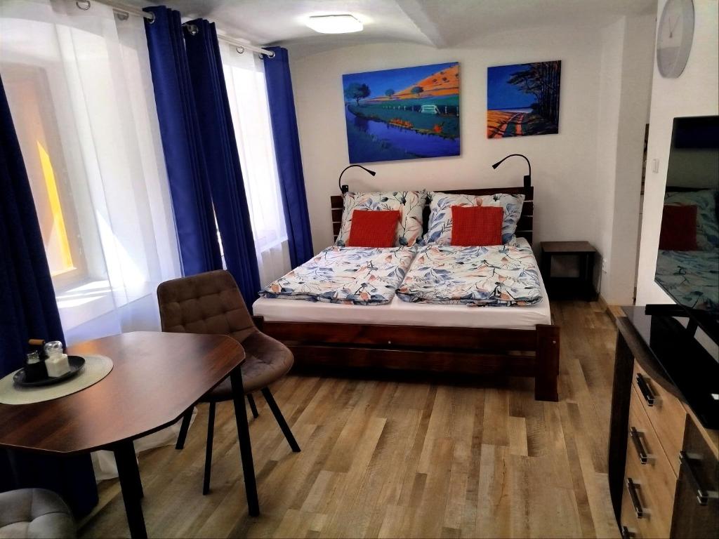 a bedroom with a bed and a table and chairs at Apartmán Kácov in Kácov
