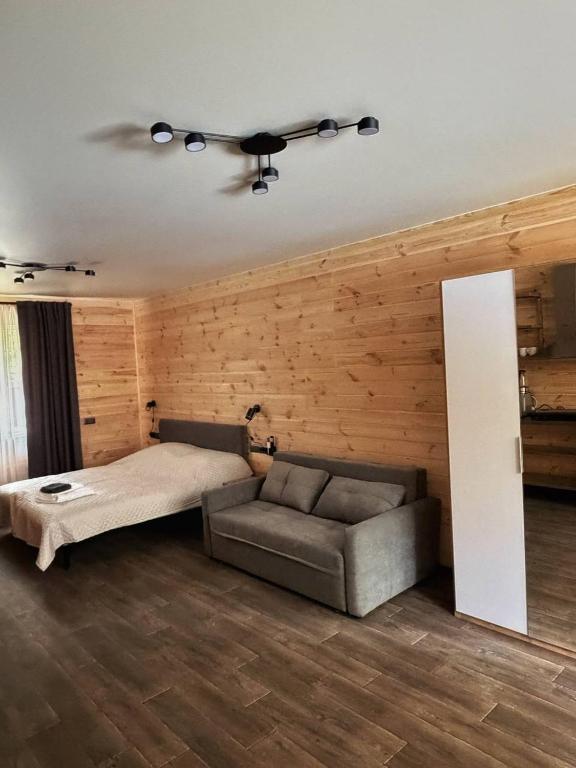 a bedroom with a bed and a couch at Joy WoodRest in Voropayev