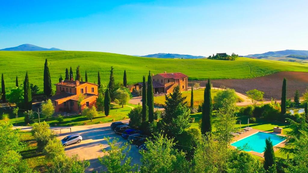 a house in a green field with a swimming pool at Agriturismo Marinello in Pienza