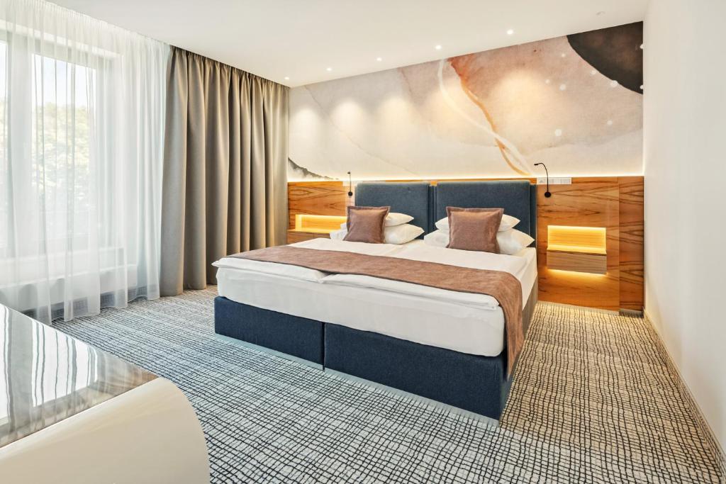 a bedroom with a large bed in a room at St. Joseph Royal Regent in Karlovy Vary