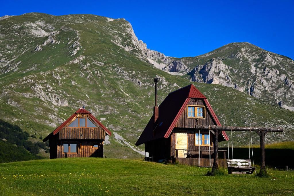 two wooden buildings in front of a mountain at Maple village in Žabljak