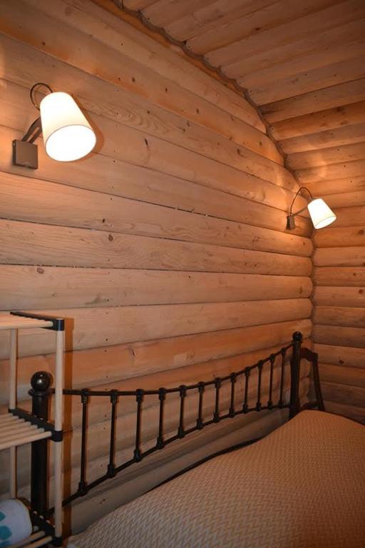 a bedroom with a wooden wall with a bed in it at Keria in Ambrolauri