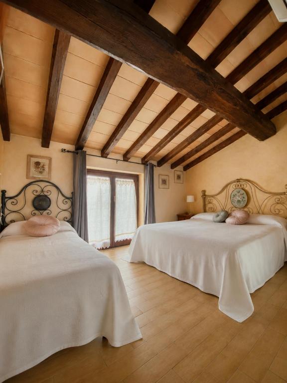 two beds in a room with wooden ceilings at La Locanda Del Tevere Slow tourism near Rome in Fiano Romano