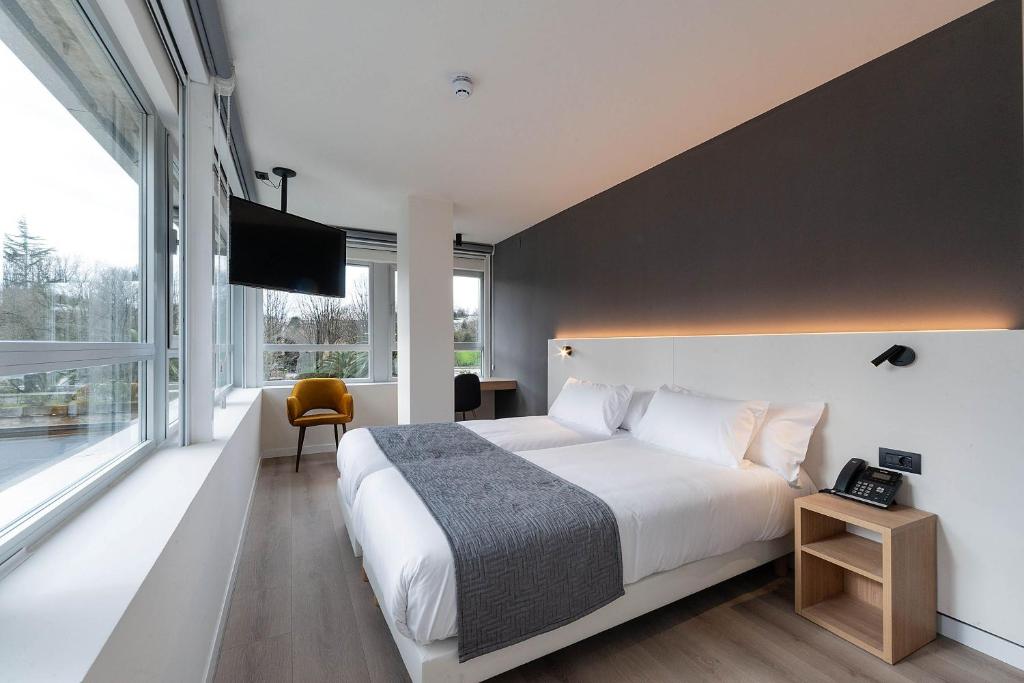 a bedroom with a large bed and a large window at Hotel Distrito Oeste by Limehome in San Sebastián
