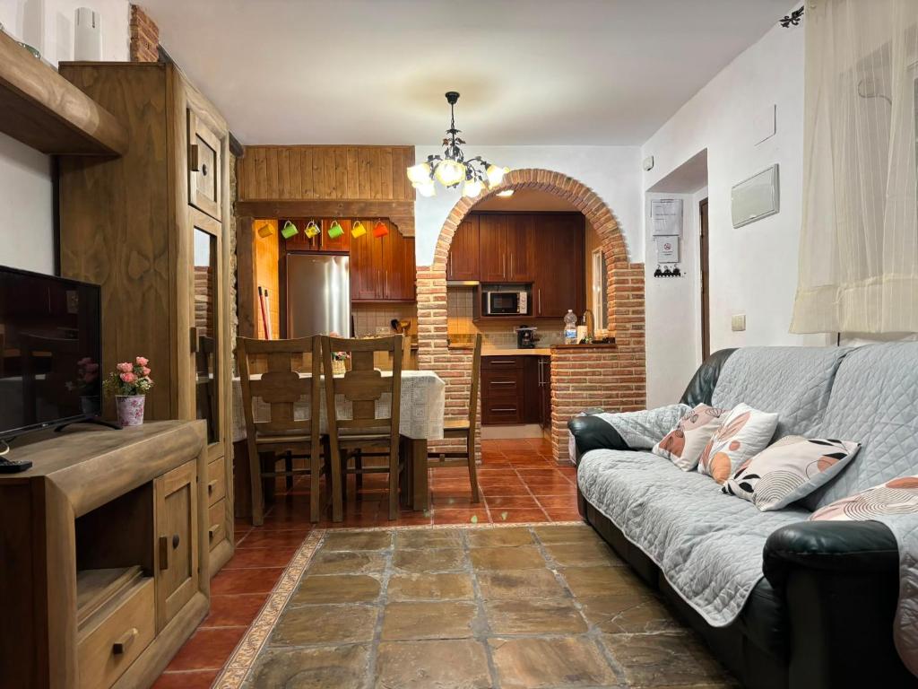 a living room with a couch and a kitchen at Casa Rural Mi Medina in Medina Sidonia