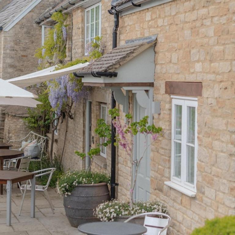 a building with a table and chairs in front of it at The Bell at Hampton Poyle in Kidlington