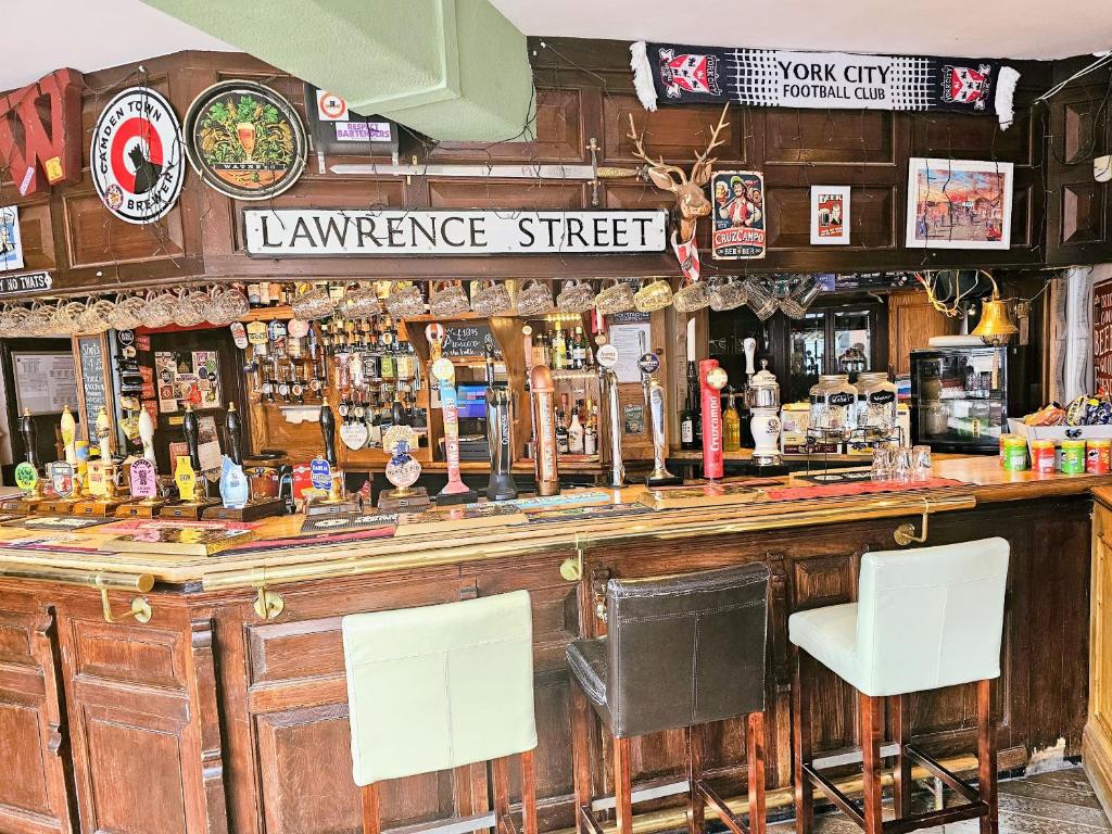 a bar with two white chairs in front of it at The Waggon & Horses in York