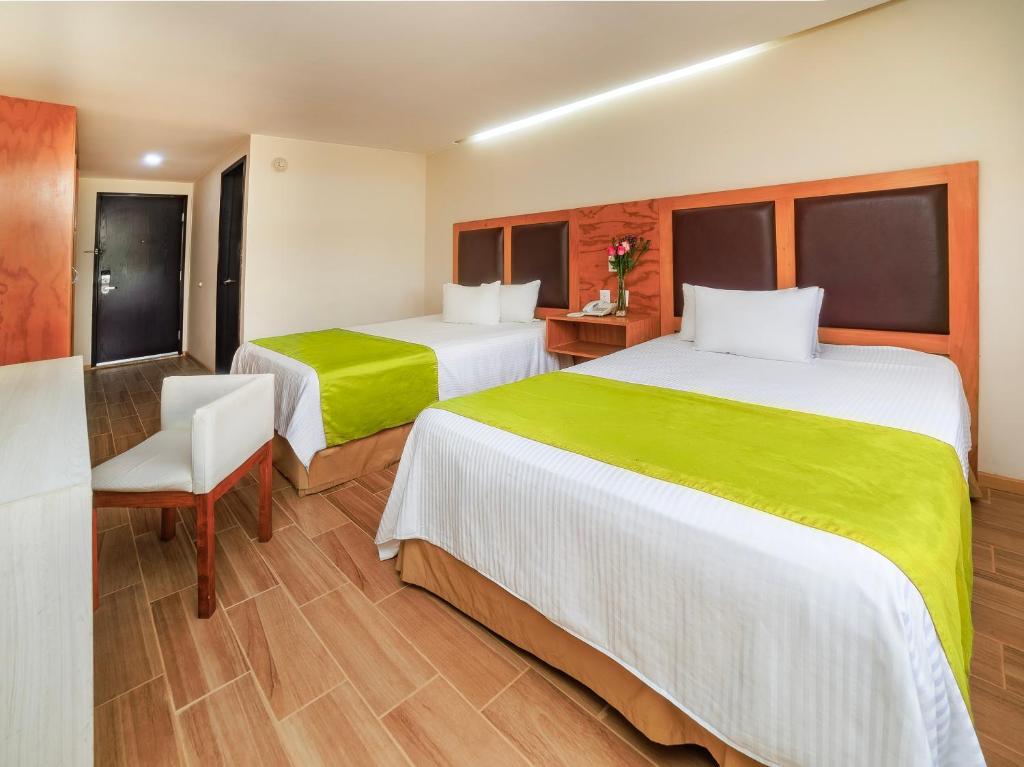 a hotel room with two beds and a chair at Collection O Paris FC Express, Poza Rica de Hidalgo in Poza Rica de Hidalgo