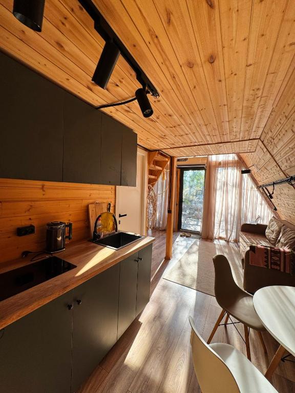 a kitchen with wooden ceilings and a living room at Glamping baytik in Verkhnyaya Alaarcha