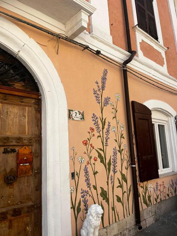 a building with a mural of flowers on the side of it at La Casetta Noble House in Casoli