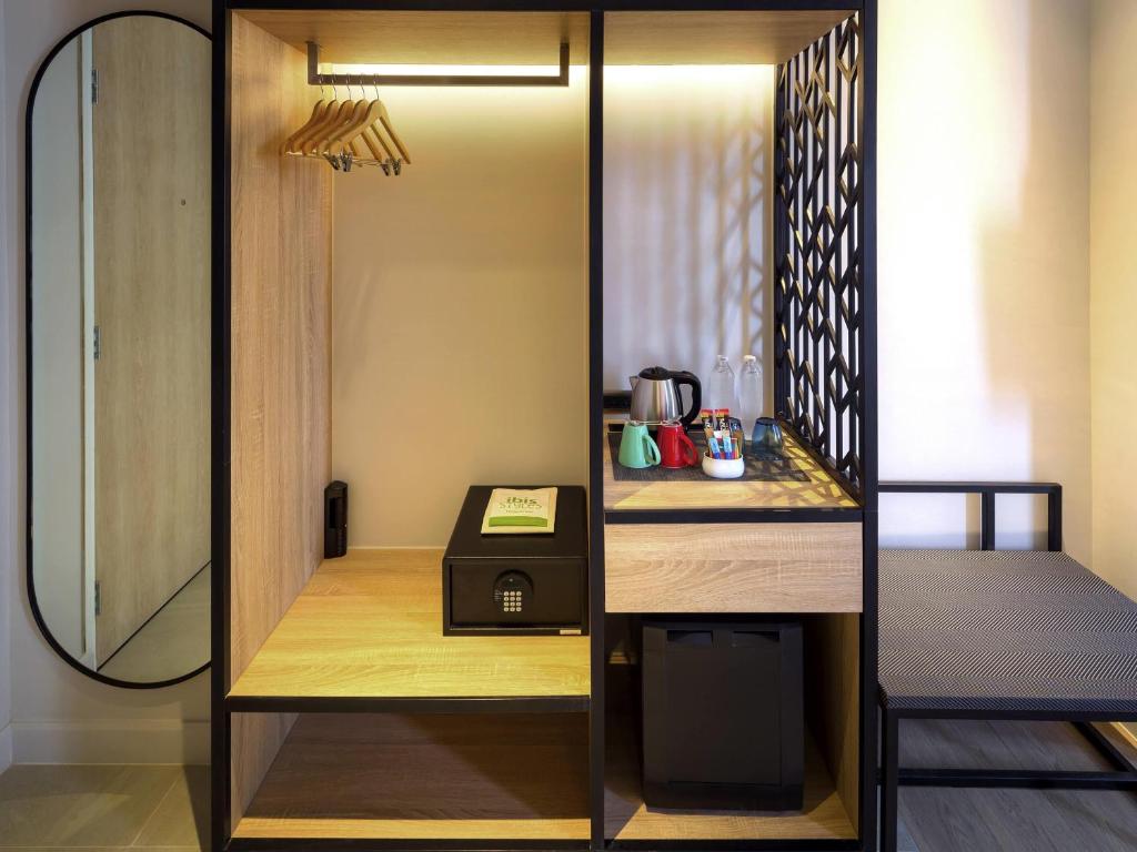 An open hotel-room storage and refreshment station with a refrigerator and kettle.