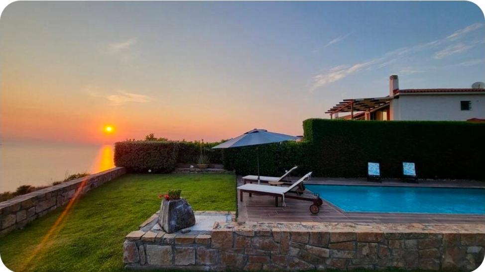 a villa with a swimming pool and a sunset at Five-Star Luxury Pool Villa, Elani in Siviri