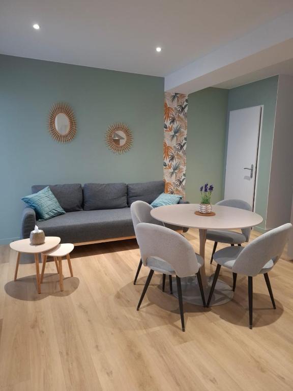 a living room with two tables and a couch at F2 neuf grande terrasse chemin de Stevenson proche Le Puy in Coubon