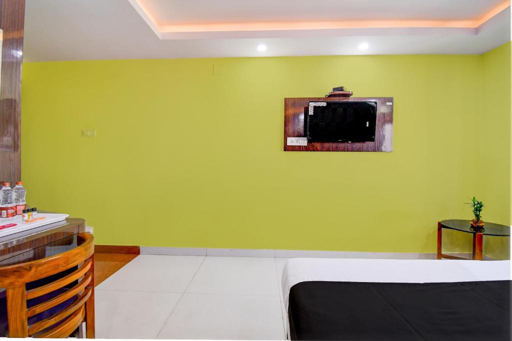 a room with a green wall with a microwave at Collection O by OYO Flavour in Āsansol