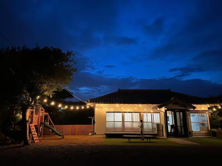 a house with a bench in the yard at night at Kujukuri SHICHIFUKU in Hasunuma
