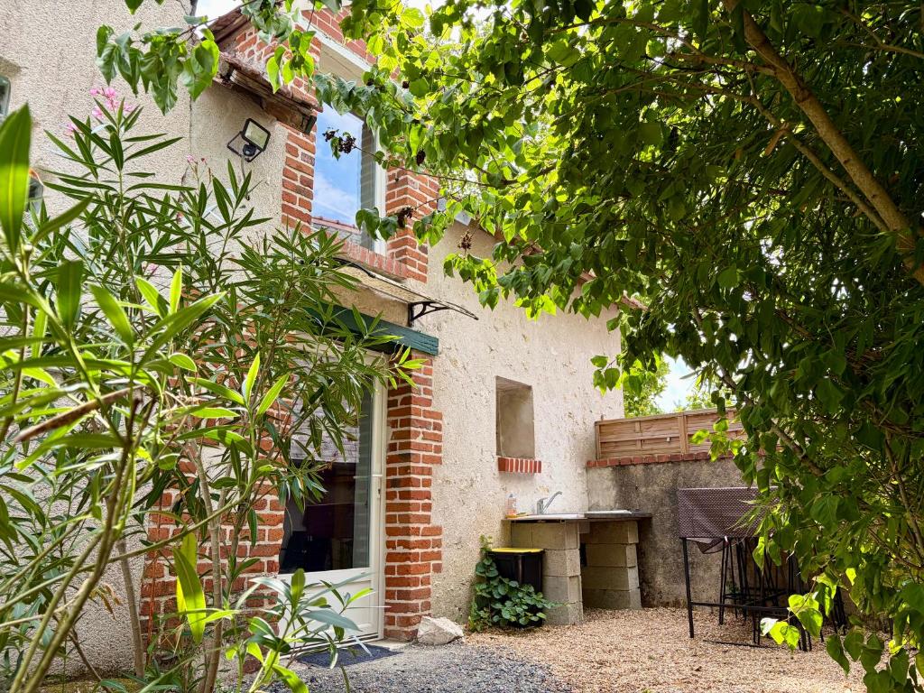 a brick building with a bench in front of it at Détente aux beaumonts in Chouzy-sur-Cisse
