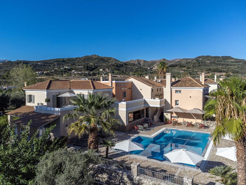 an aerial view of a house with a swimming pool and palm trees at Harmony Hotel Apartments in Selianitika