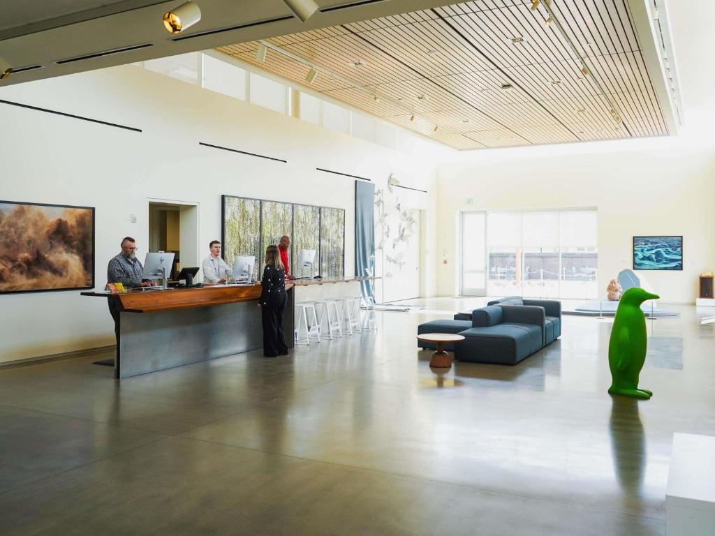 a lobby with people working at a reception desk at 21c Museum Hotel Bentonville - MGallery in Bentonville