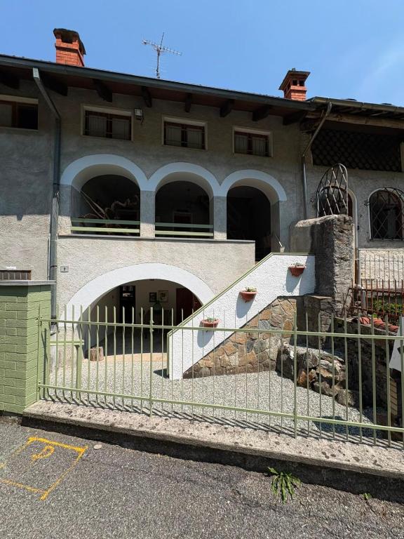 ein Gebäude mit einem Zaun vor einem Gebäude in der Unterkunft CaDMARTA in Vico Canavese
