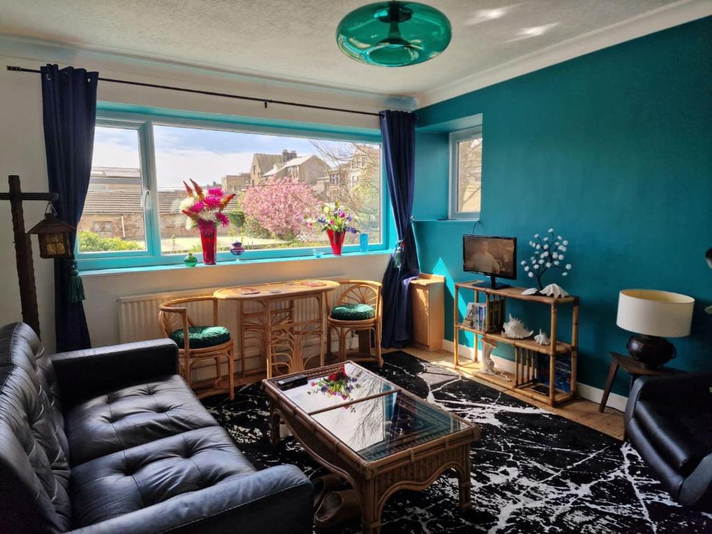 a living room with a couch and a table and a window at Host & Stay - Beachcomber Cottage Apartment in Morecambe