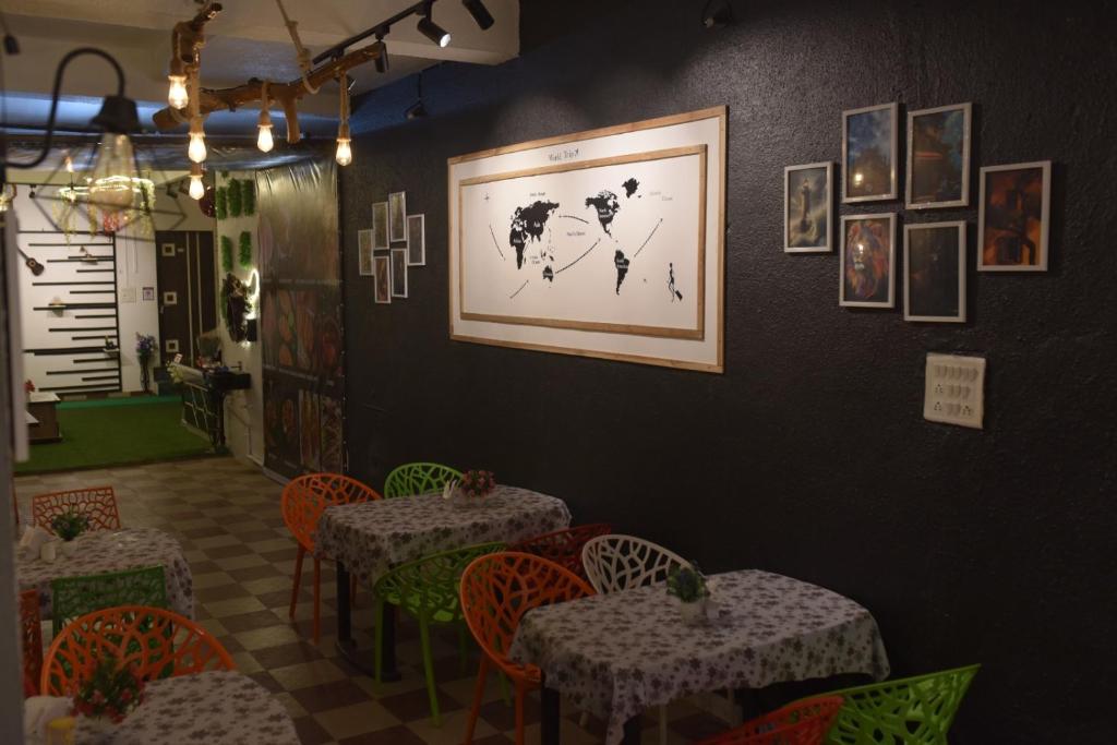 a restaurant with tables and chairs and a picture on the wall at Coastal Gateway Resort in Revadanda