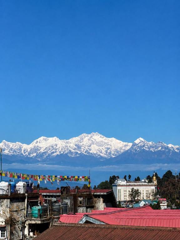 a city with snow covered mountains in the background at The Potola Hotel And Restaurant With Parking Facility in Darjeeling