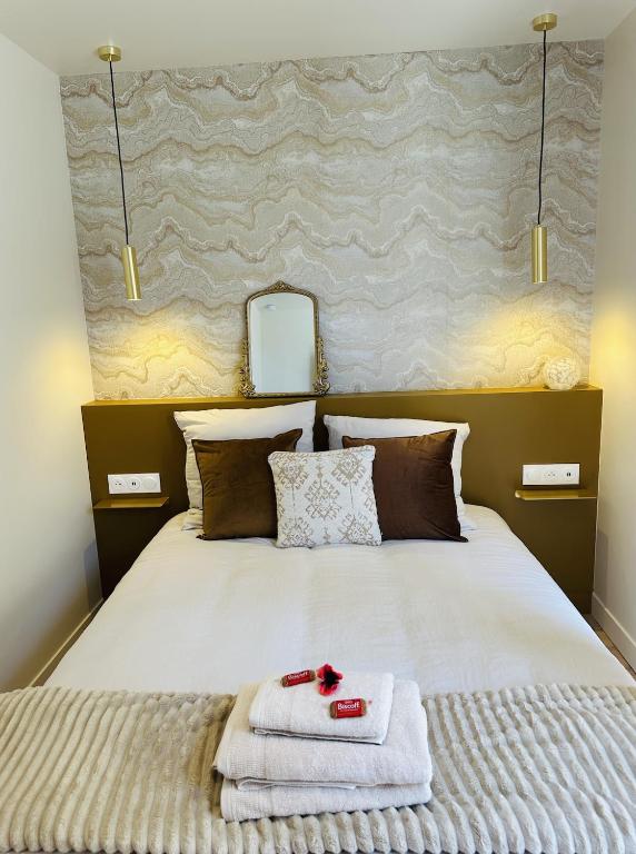 a bedroom with a bed with towels on it at 6 Suites Signature in Saint-Jacques-de-la-Lande