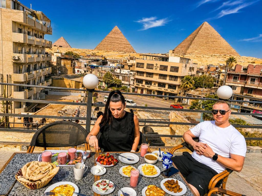 a group of people sitting at a table with food at Red Pyramids Hotel in Cairo