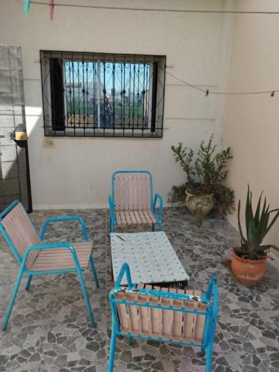 a patio with two chairs and a table and a bench at دار المحبة - Dar El Mahabba in Tazarka