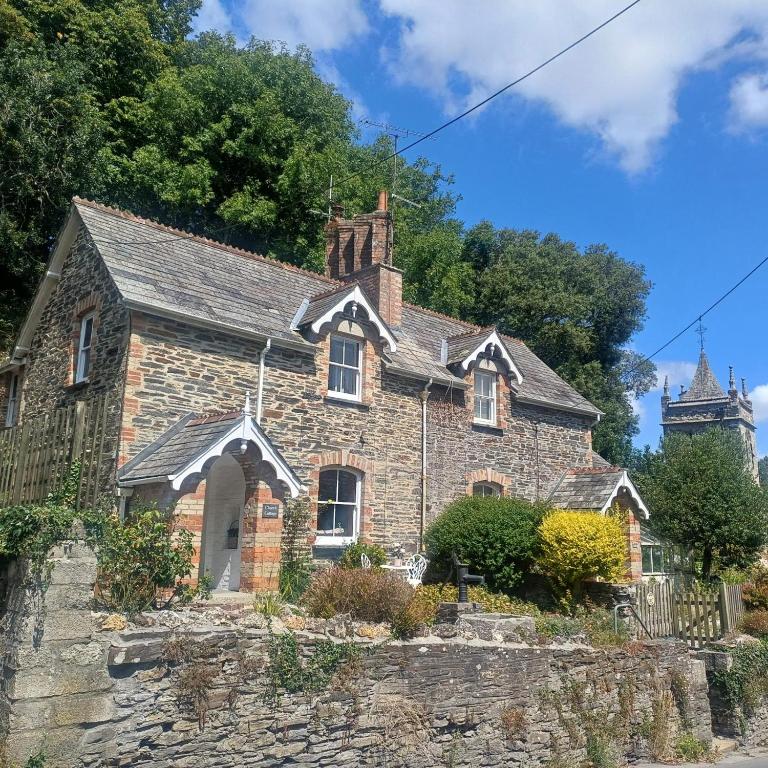 an old stone house with a church in the background at 2 Bed in Wadebridge oc-83130 in Little Petherick
