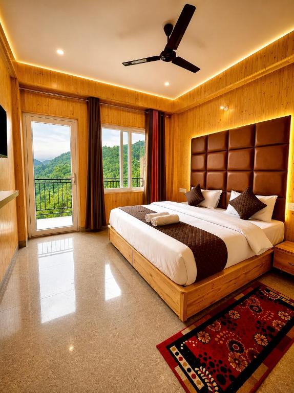 a bedroom with a large bed and a large window at The Amber Retreat - Best Property In Mussoorie #Luxury Rooms #Balcony #Parking #Budget Friendly #Mountain View #Restaurant #Couple Friendly in Mussoorie
