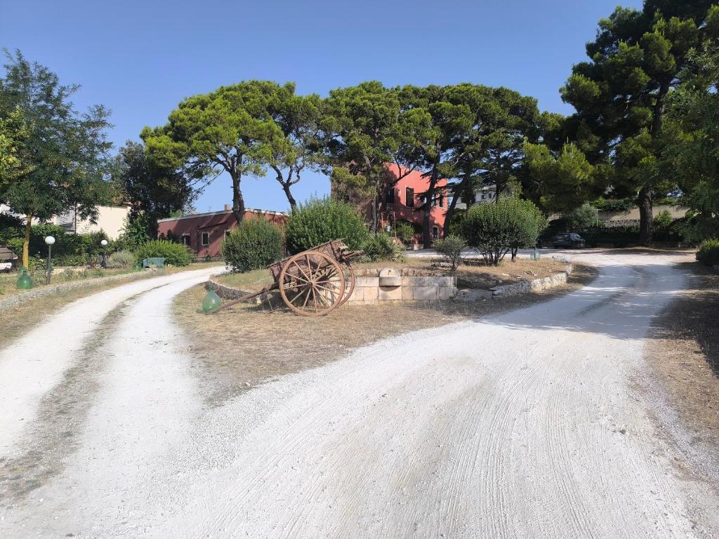 an old wagon sitting on the side of a dirt road at Residenza Borgo Francescano in Gioia del Colle