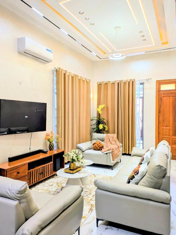 a living room with couches and a flat screen tv at R&E Apartments in Dodoma