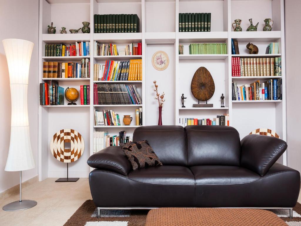a black leather couch in a living room with bookshelves at Quartprimera Apartments in Barcelona