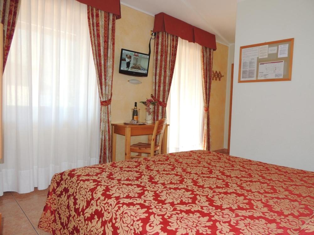 a bedroom with a bed and a window and a desk at Albergo Eden in Passo del Tonale