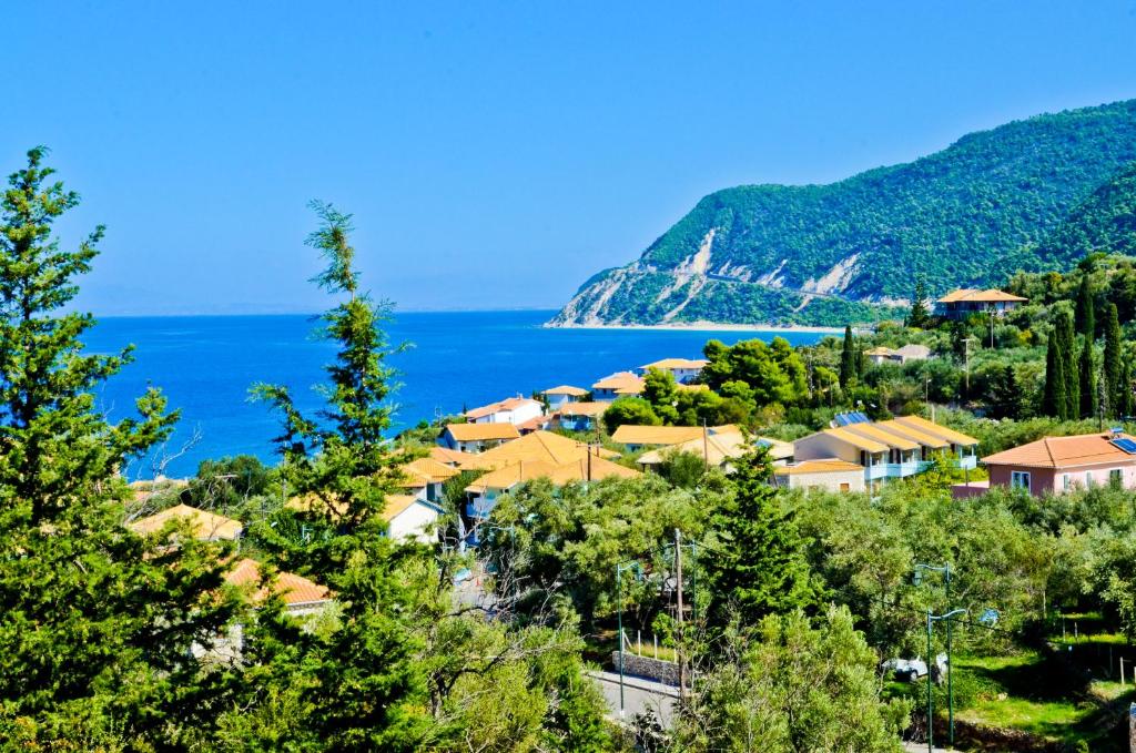 a town on a hill next to the ocean at Katerina's Village Agios Nikitas in Agios Nikitas