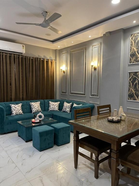 a living room with a blue couch and a table at Couple friendly spacious 1BHK in Indore